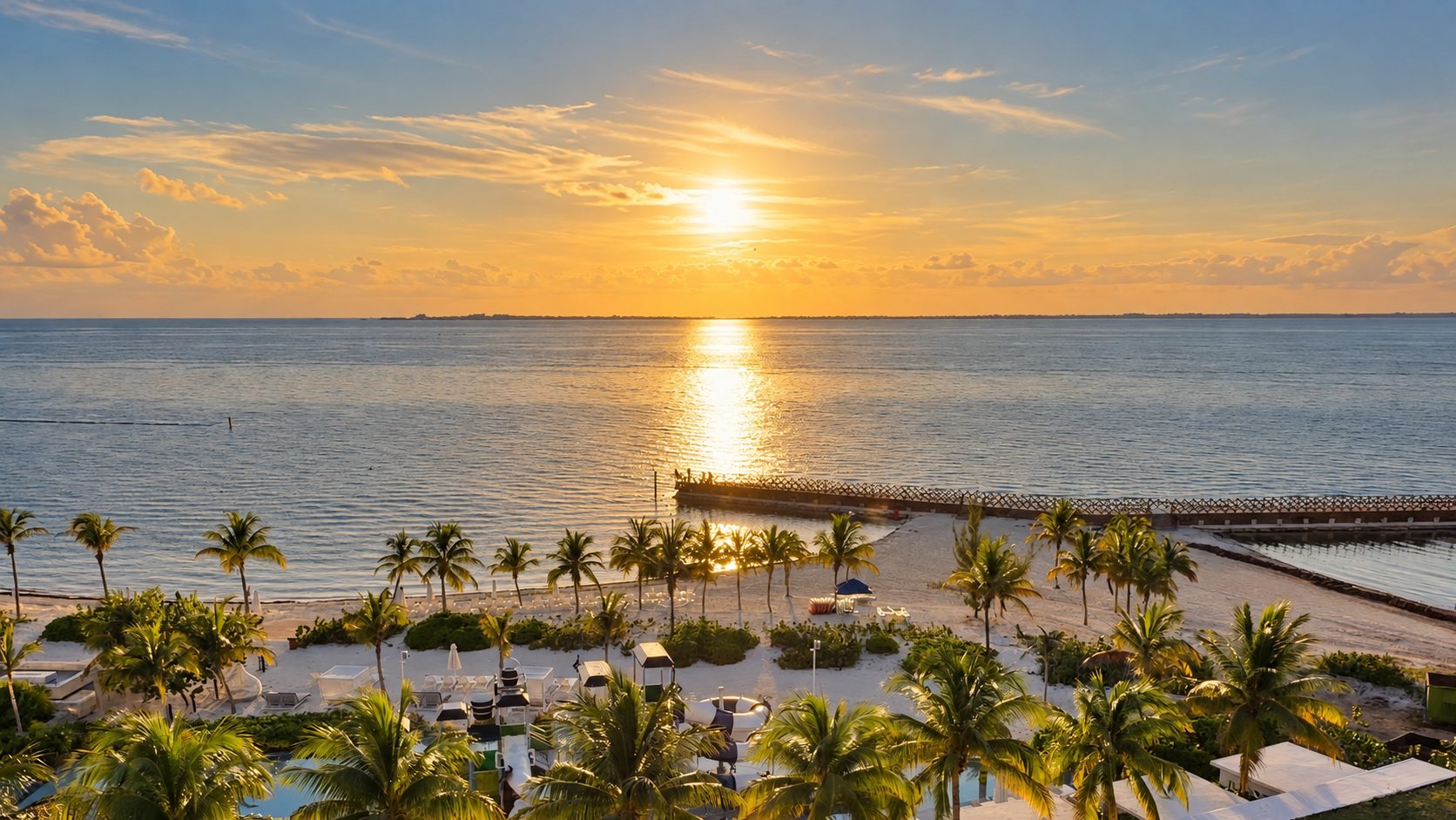 Golden sunset over the beach and palms at SLS Playa Mujeres